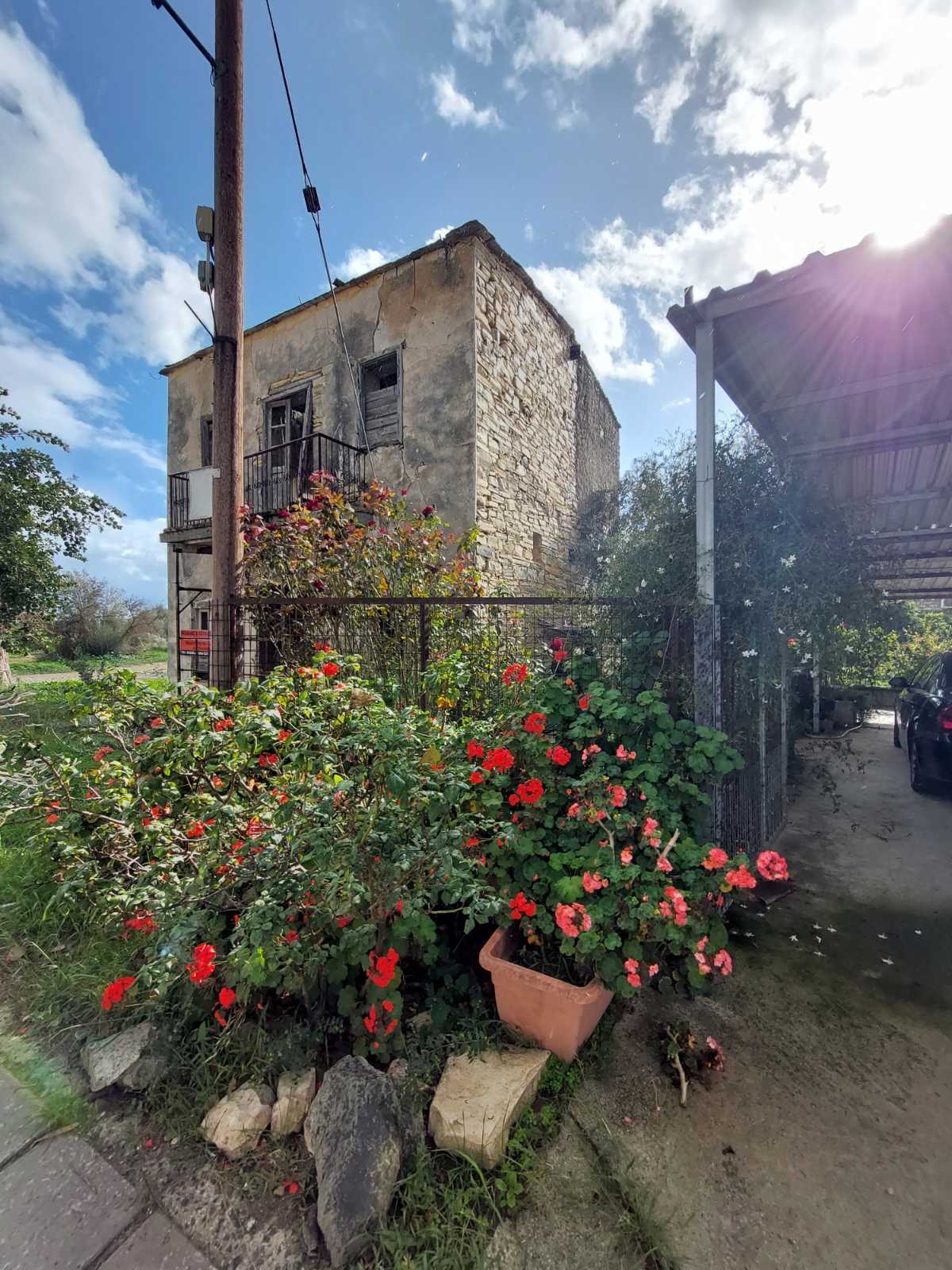Old stone house before restoration, side view with garden