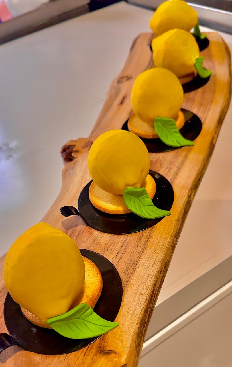 Lemon-shaped handmade desserts on a wooden board at December9